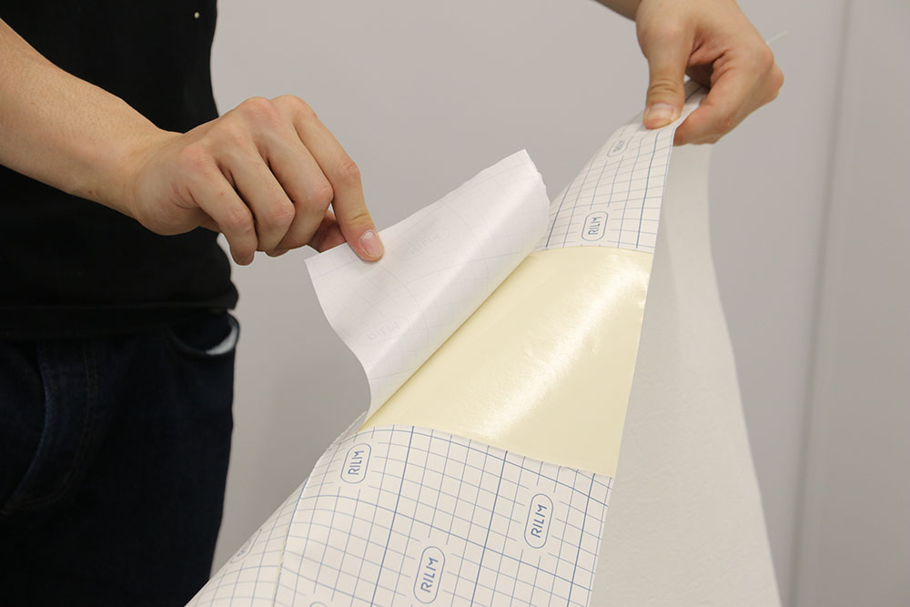 ③剥離紙の一部をめくり、位置を決めて仮止めする