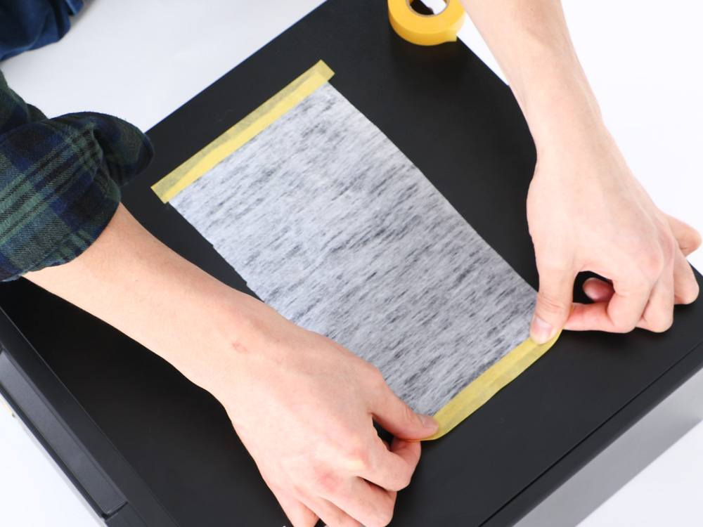 次に、吸排気口に合わせてフィルターの短辺両側をテープで貼り付けます。