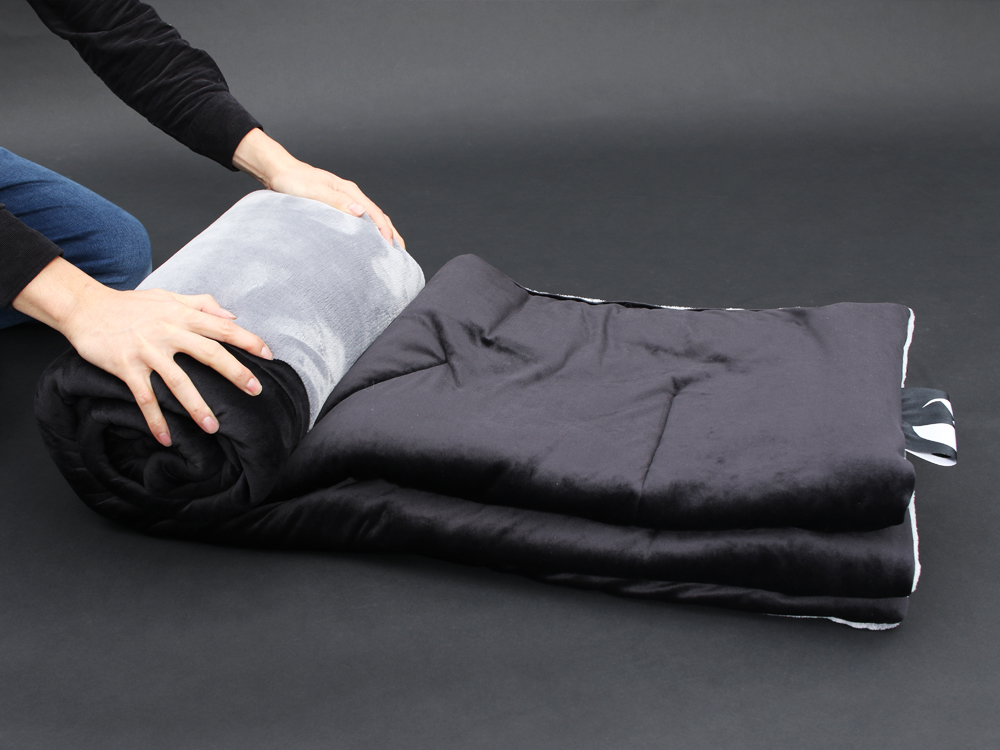 毛布をくるくると丸めて紐で結ぶ